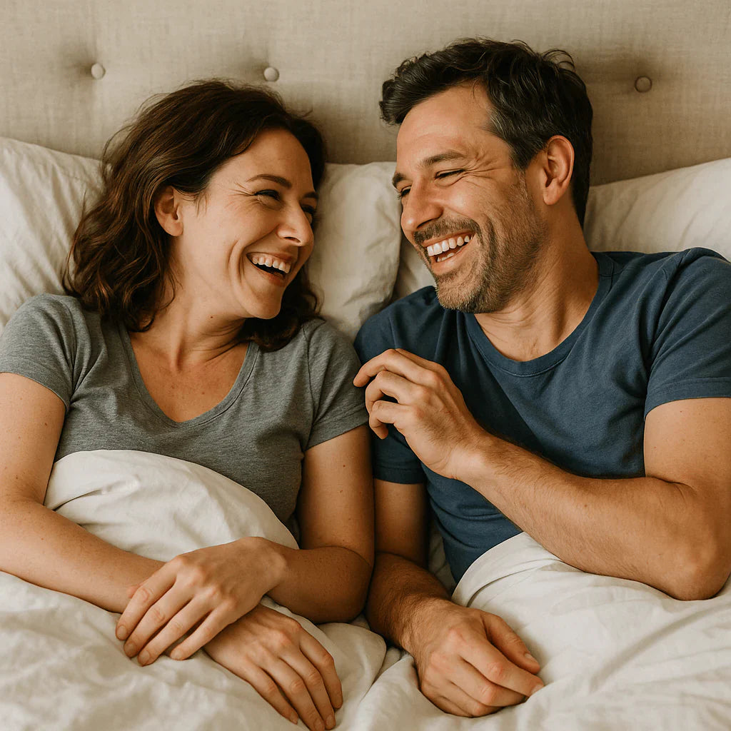 Happy couple sharing a joyful moment in bed, enjoying laughter and connection.